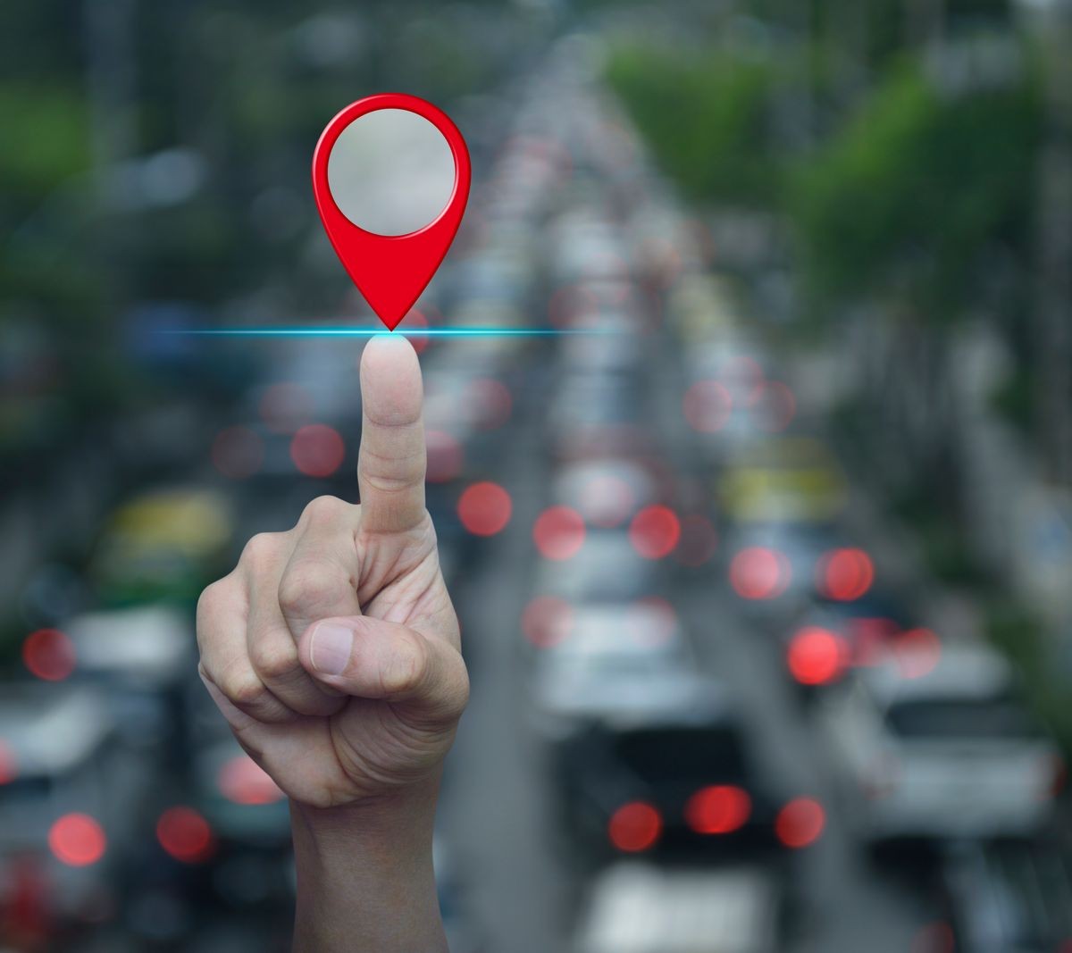 Hand pressing map pin location button over blur of rush hour with cars and road, Map pointer navigation concept