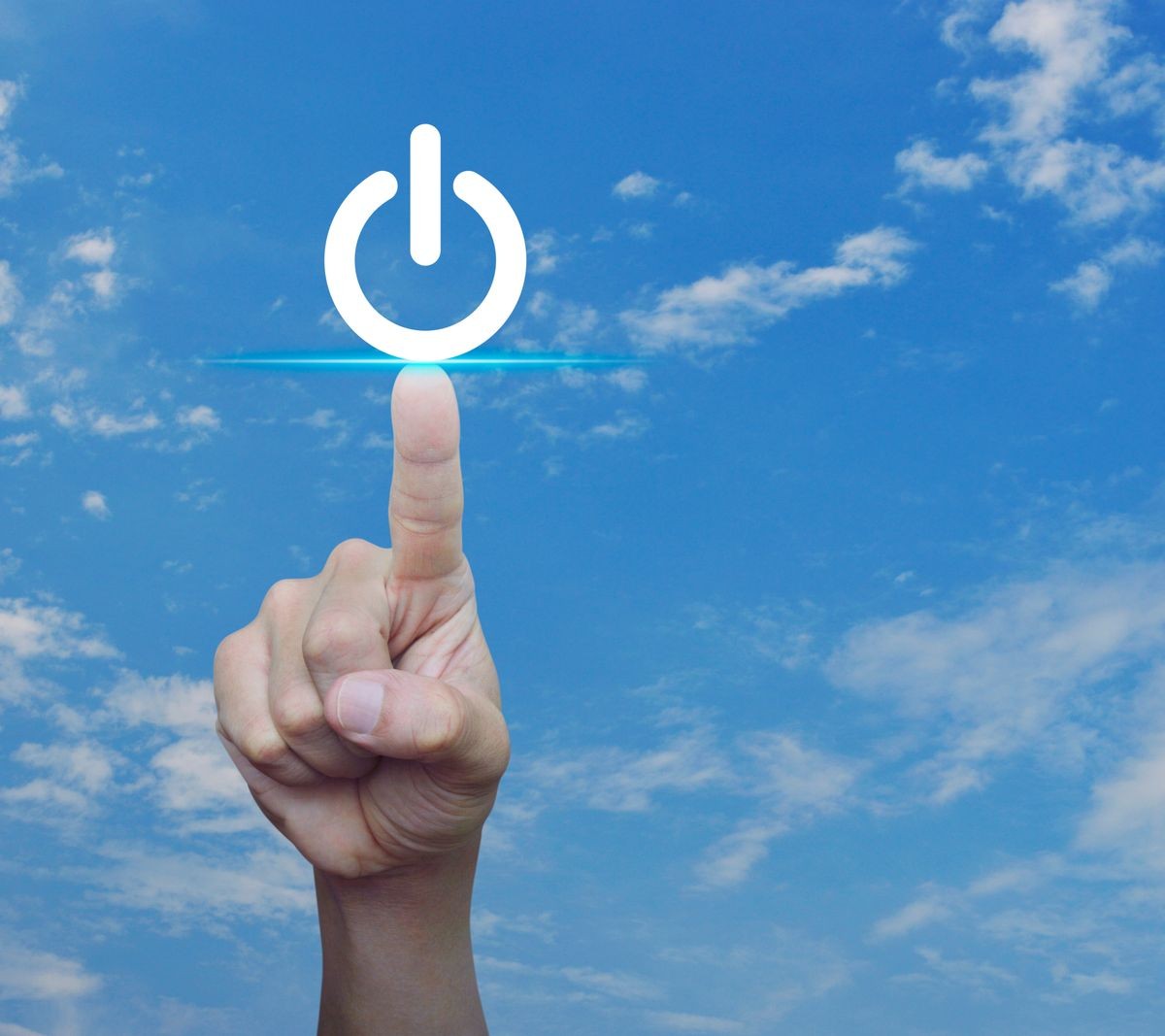 Hand pressing power button over blue sky with white clouds, Start up business, industry concept